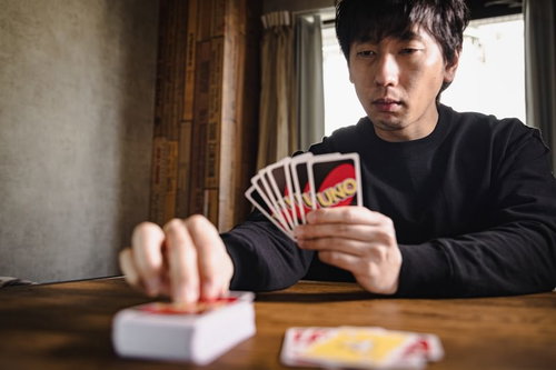 生まれつきポーカーフェイスのプレイヤー、UNOで真顔の男性