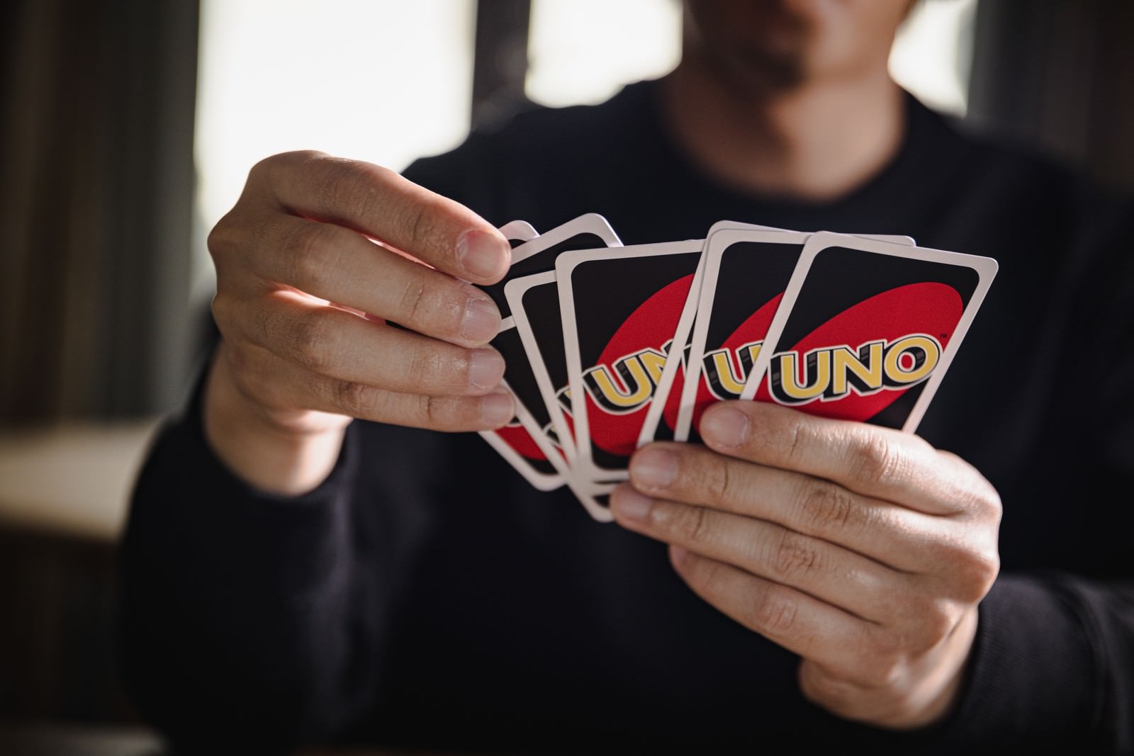 UNOのカードを扇状に広げて手に持っているプレイヤー