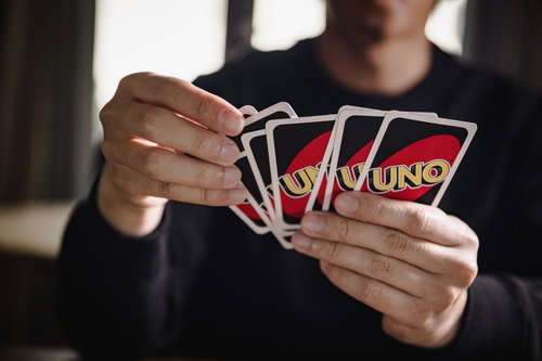 7枚の手札を扇状に広げてチェックするUNOプレイヤー