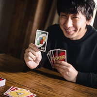 つれー、他に出せるカードないわーとドロー4を出す男性の写真