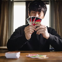 手札にろくなカードがない男性がトランプで困った表情の写真
