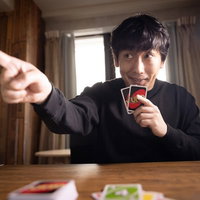 UNOの宣言ミスを指摘する黒シャツの男性の写真