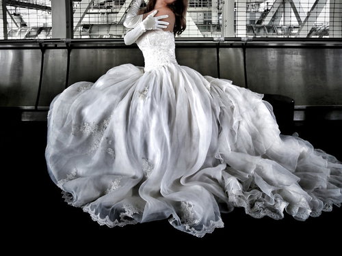 高架下のコンクリート空間でウェディングドレス姿の女性