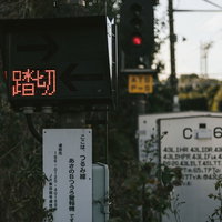 鶴見線の踏切と線路風景、赤い信号機が点灯する駅周辺の写真