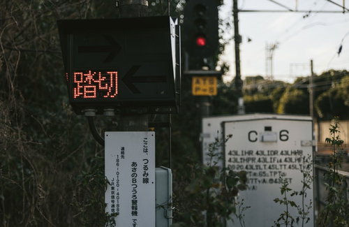 鶴見線の踏切と線路風景、赤い信号機が点灯する駅周辺