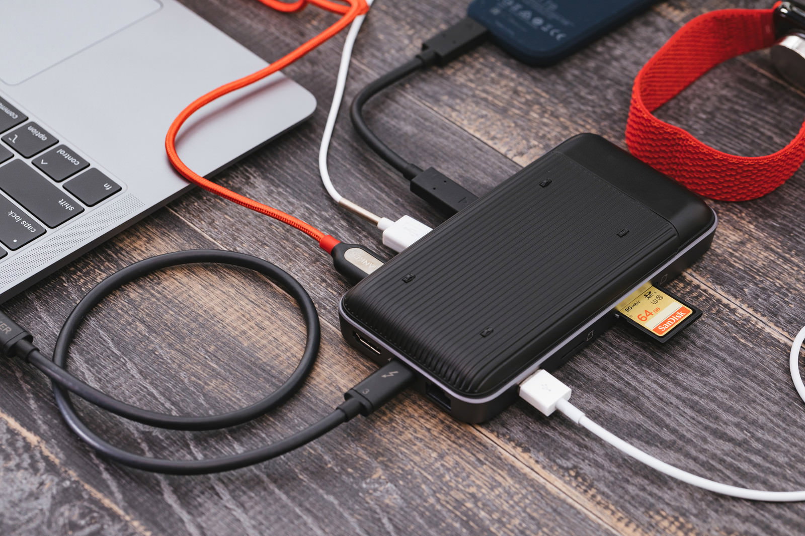 USB-Cハブに複数のケーブルとSDカードを接続したMacBook周辺