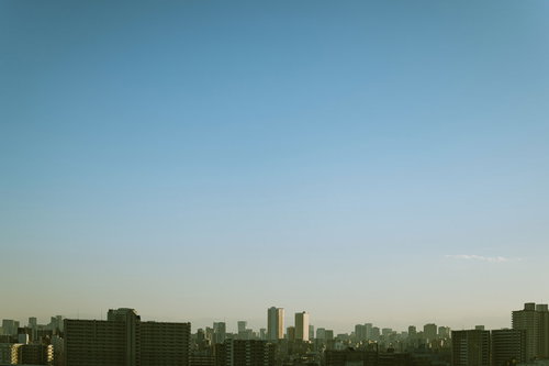 都会のマンション群が並ぶ朝焼けの空と都市景観