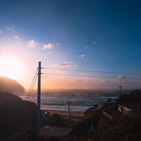 日が沈む神津島の海岸に寄せる荒波と夕焼けの風景の写真