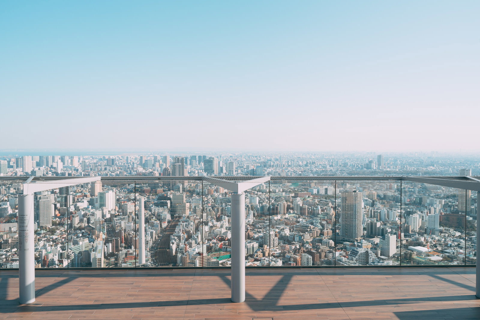 渋谷スカイの展望台から見下ろす東京都心の高層ビル群と青空