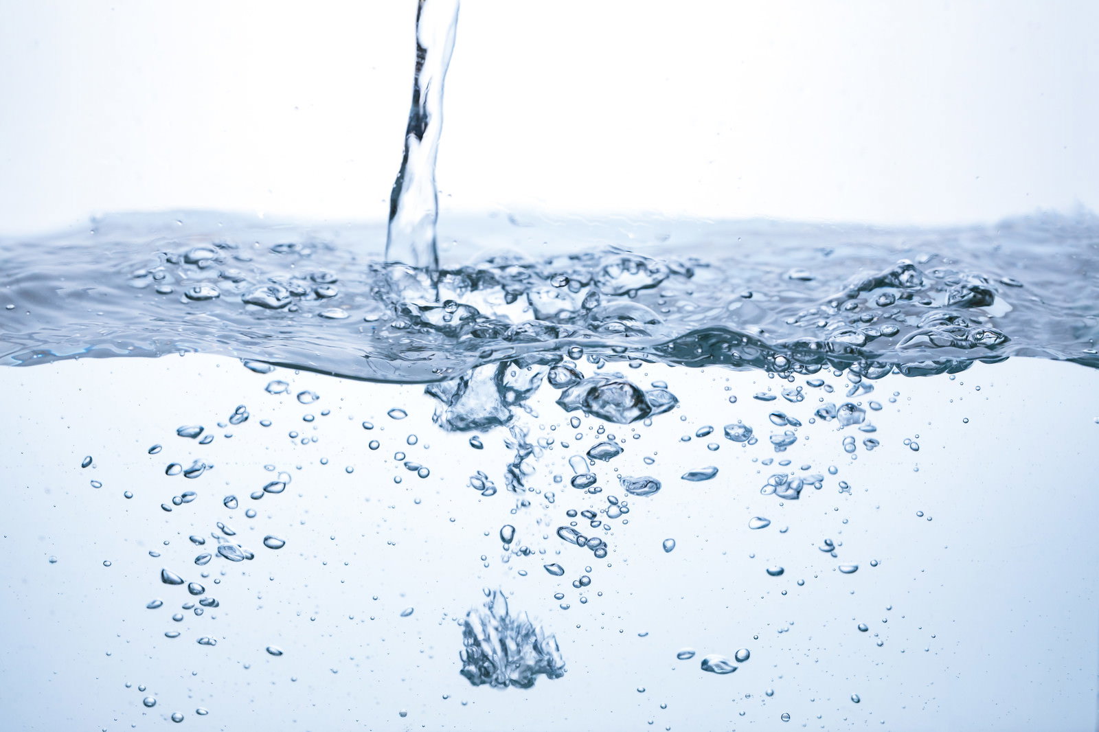 透明な水中に気泡が立ち上がり、水面に波紋が広がる水の断面