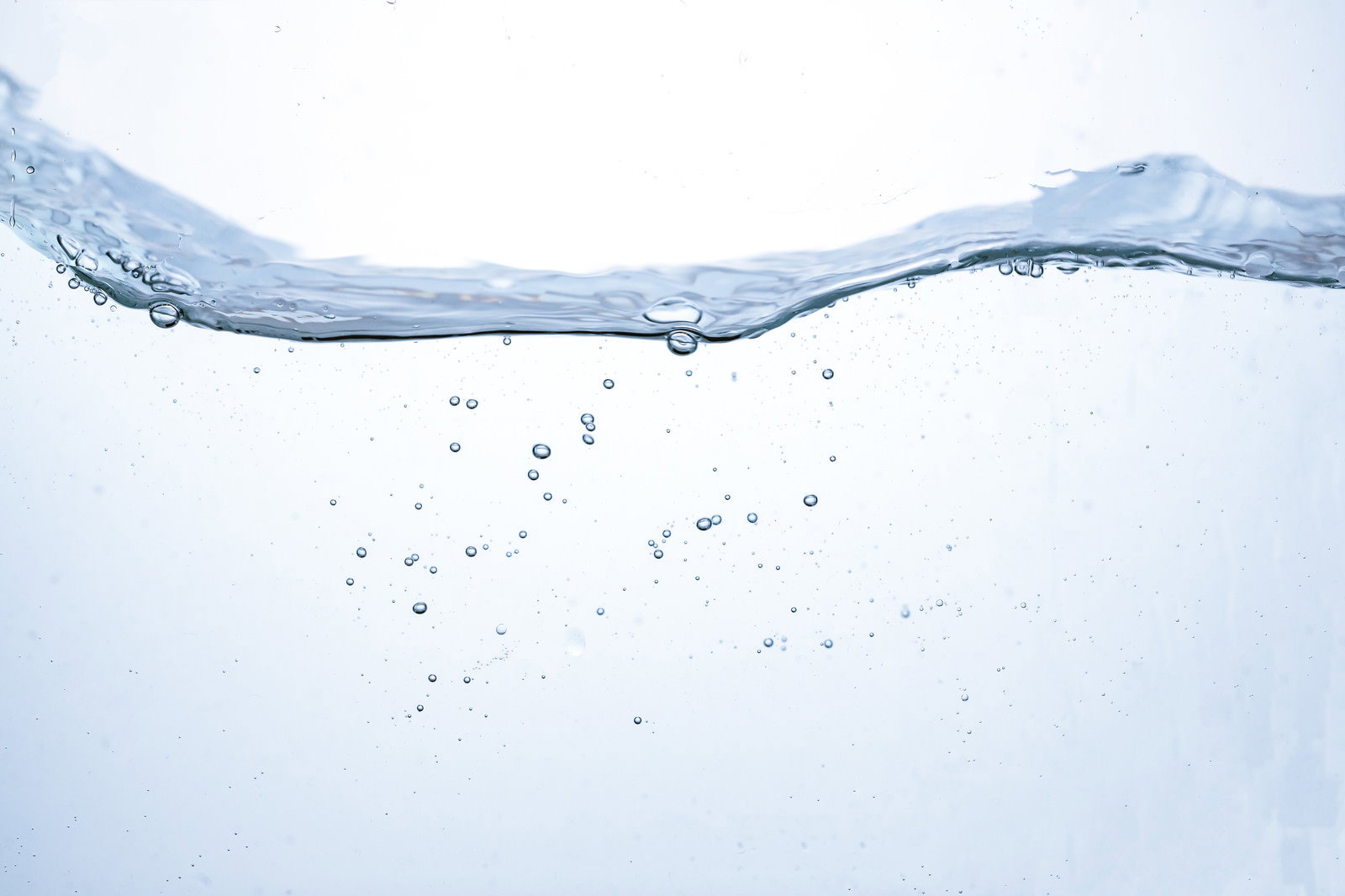 透明な水の中に細かな気泡が浮遊し、水面に波紋が広がる様子