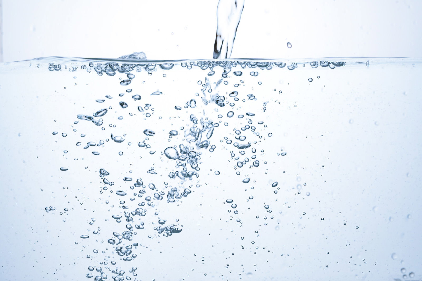 透明な水の中に無数の気泡が舞い上がる瞬間を捉えた清涼感あふれる写真