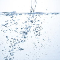 水槽の中で水を注いだ瞬間に発生する気泡の写真