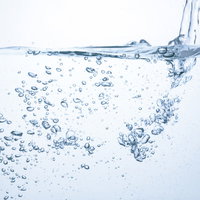 透明な水中に上昇する気泡とミネラルウォーターの写真