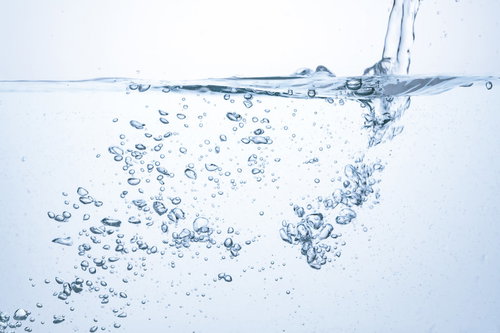 透明な水中に上昇する気泡とミネラルウォーター