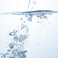 勢いよく注がれるミネラルウォーターと気泡の写真