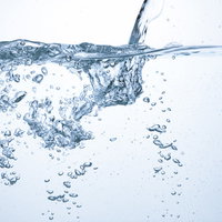 水中の気泡とはじける水しぶきの写真