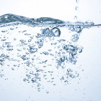 水槽に広がる波と立ち上る気泡の透明感と清涼な水中風景の写真