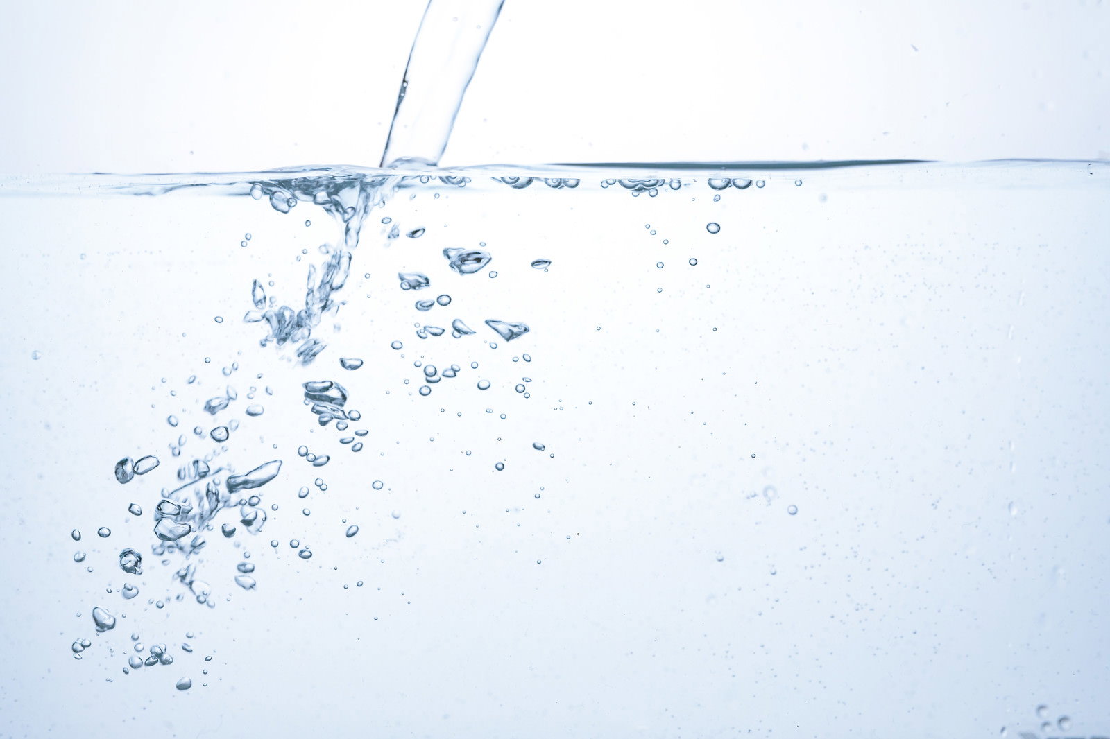 透明な水中に注がれる水と無数の気泡が舞い上がる清涼感のある様子