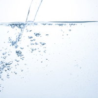 水槽に注ぎ込まれるミネラルウォーターと気泡の写真