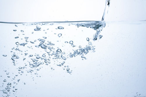ミネラルウォーターにチョロチョロと注ぐ水と気泡