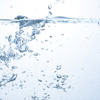 ミネラルウォーターの断面と水中に浮かぶ気泡の写真