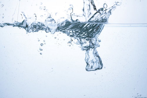 水槽に勢いよく水が注がれ気泡と波紋が広がる瞬間