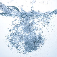 勢いよく入った水と気泡が広がる瞬間、透明な液体に浮かぶバブルの写真