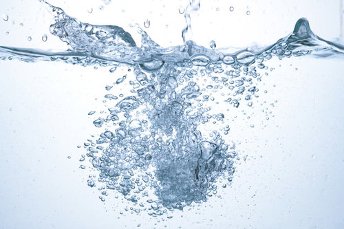 勢いよく入った水と気泡が広がる瞬間、透明な液体に浮かぶバブル