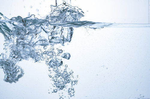 注がれたミネラルウォーターの水中断面と上昇する気泡