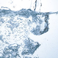 水槽に注がれる水と気泡が立ち上る瞬間、透明な水中での炭酸水の写真