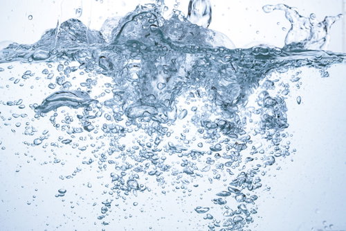 水槽内に勢いよく注がれるミネラルウォーターと気泡