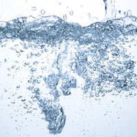 ミネラルウォーターが注がれる水槽の気泡が立ち上がる様子の写真