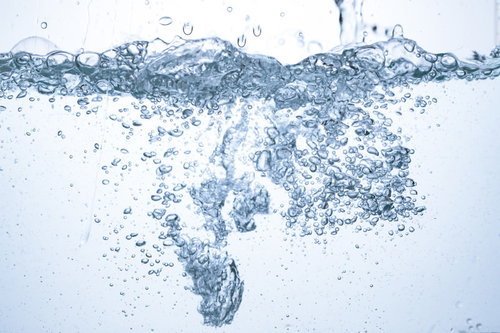 ミネラルウォーターが注がれる水槽の気泡が立ち上がる様子