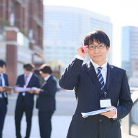 外回りの営業部隊と上司の方、街中で打ち合わせの写真