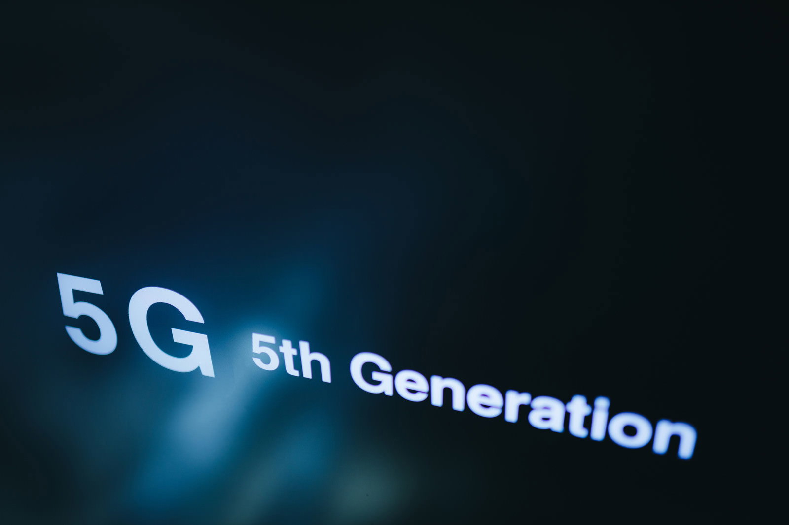 青い光で5G 5th Generationの文字が表示されたディスプレイ