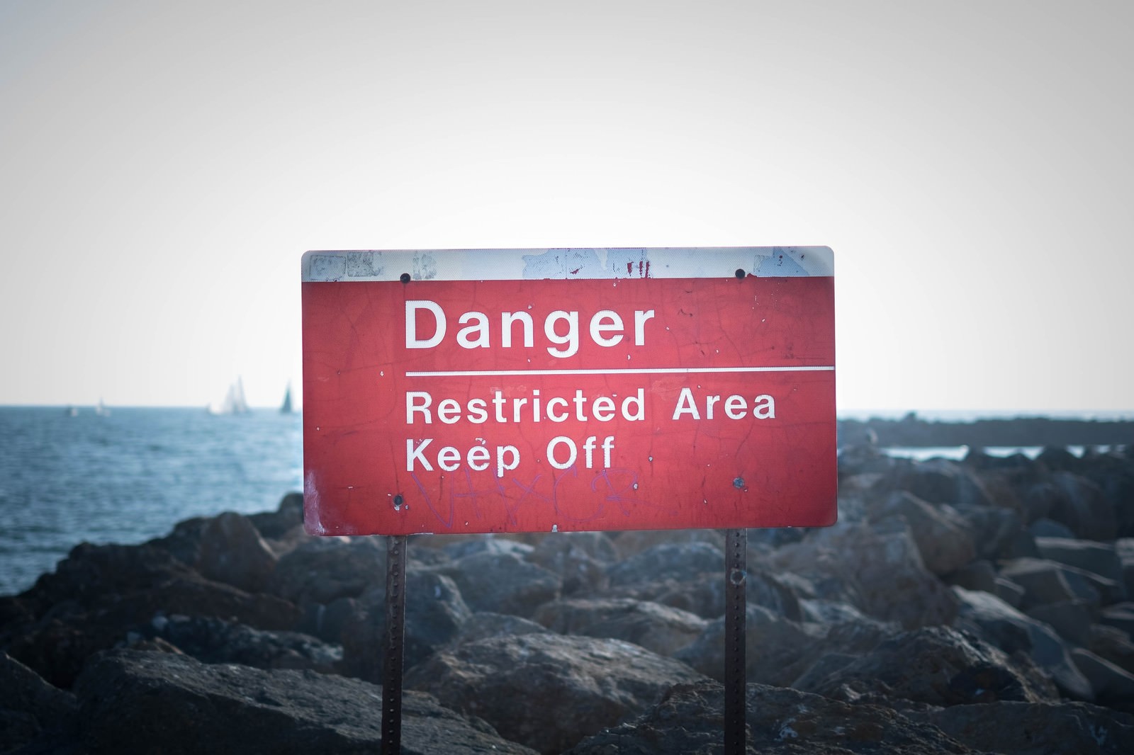 赤い危険看板にDanger Restricted Area Keep Outの文字