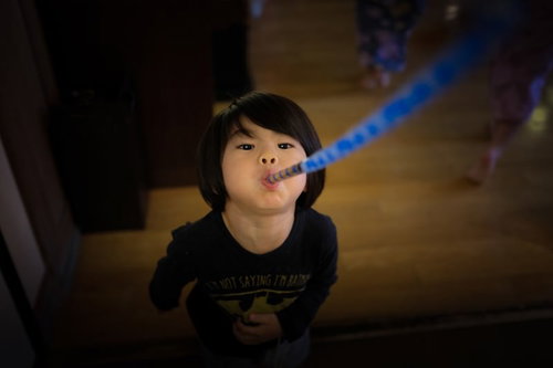 ピロピロプーを吹いて遊ぶ子供の楽しい室内遊び