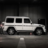 屋内駐車場に停められた白いオフロード車の高級SUVの写真