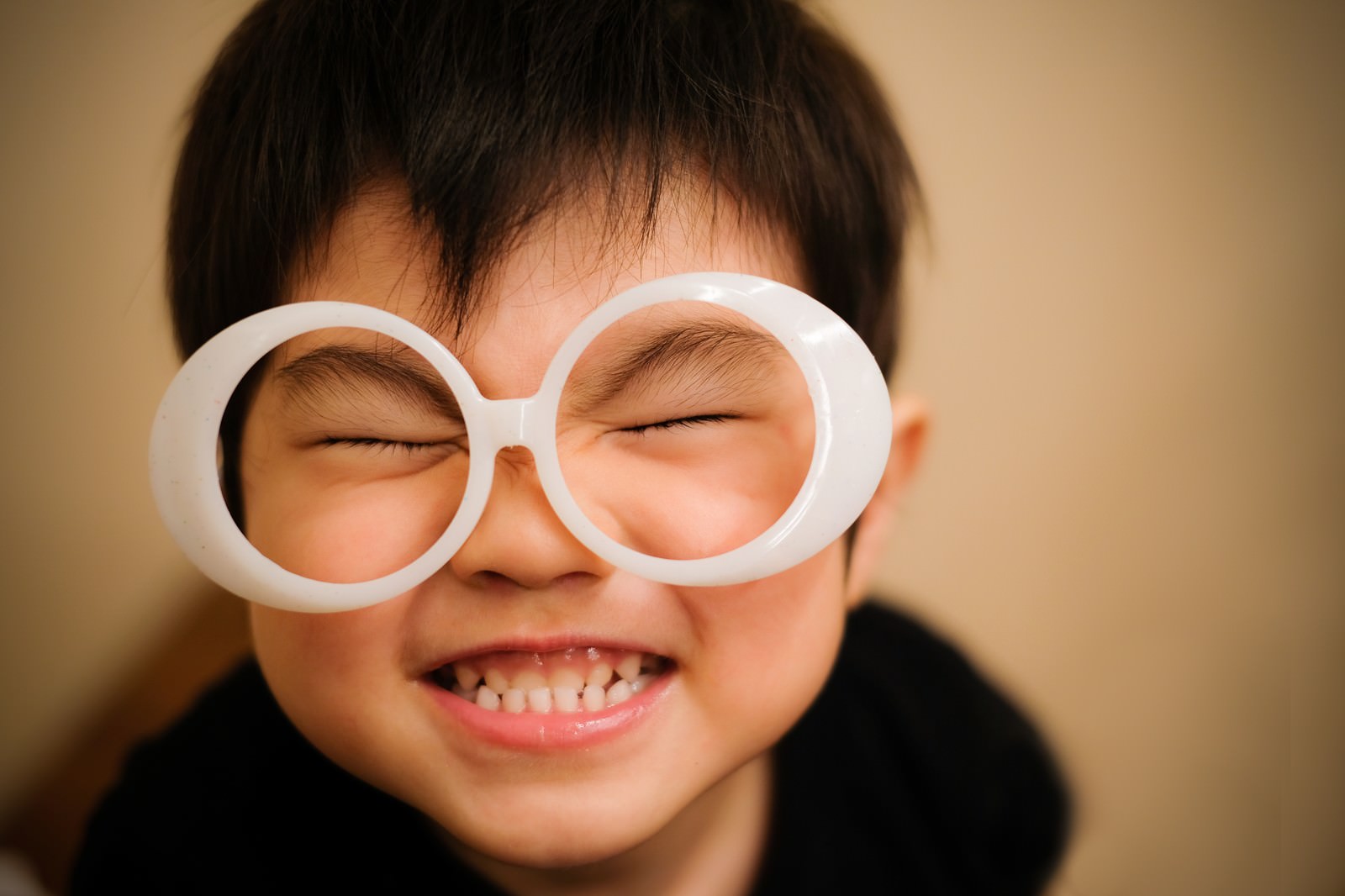 白い丸い眼鏡をかけて満面の笑みを浮かべている子供