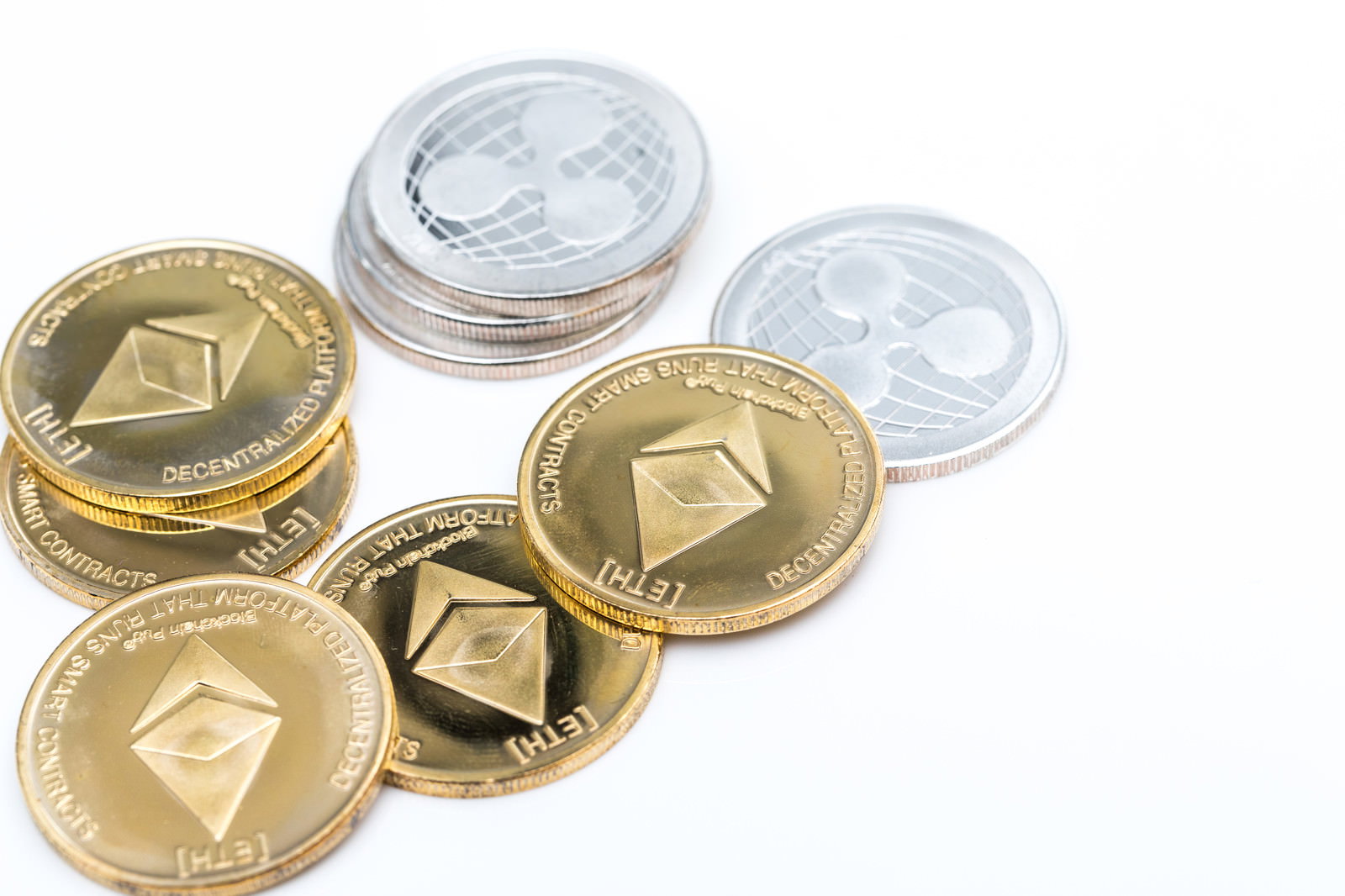 金色と銀色のETHとXRPアルトコインが重なって配置されている様子