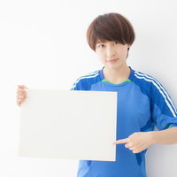ホワイトボードで解説するサッカー女子選手の戦術指導の写真