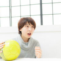 ハラハラする展開で中継に釘付けのサッカー女子がボールを持つの写真