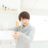 キッチンで料理上手な嫁がタブレットでレシピ確認の写真