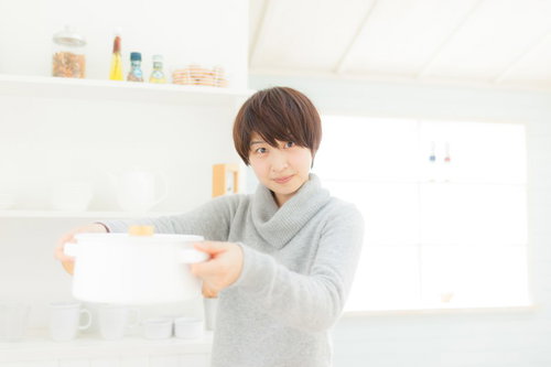 キッチンで料理上手な嫁がタブレットでレシピ確認の写真