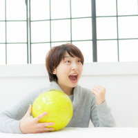 サッカーの試合をテレビ観戦して叫ぶ女性の応援の写真