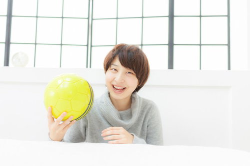 サッカーボールを持って笑顔の若い女性アスリート