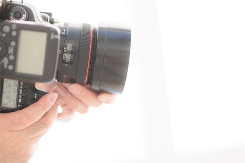 タテイチ（縦位置）構図でカメラを構える男性フォトグラファー