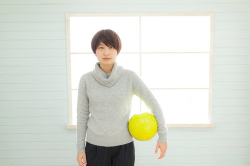 タートルネックのサッカー部女性コーチがサッカーボールを持つの写真