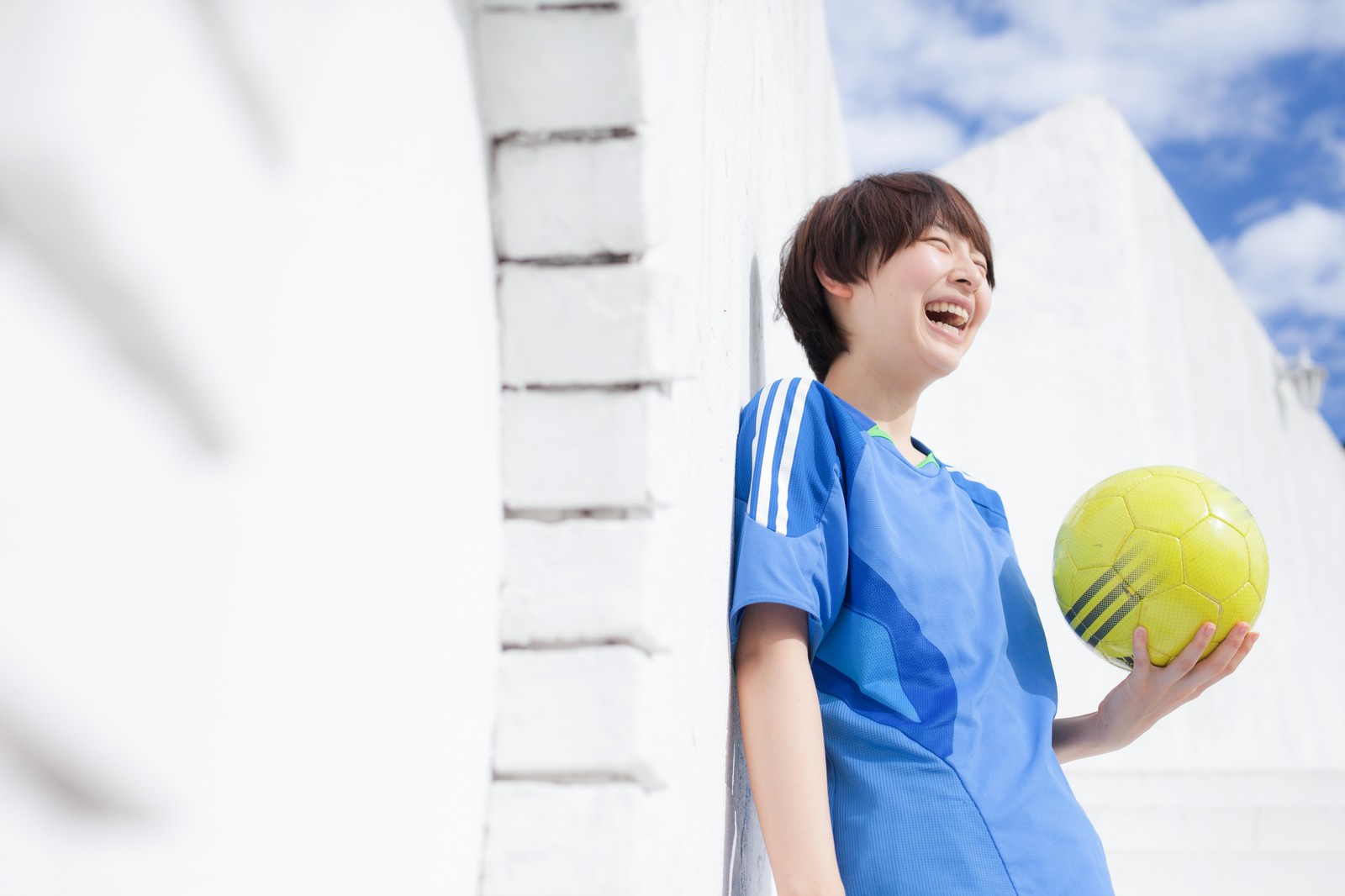 サッカーボールを持って笑う子供［モデル：八木彩香］